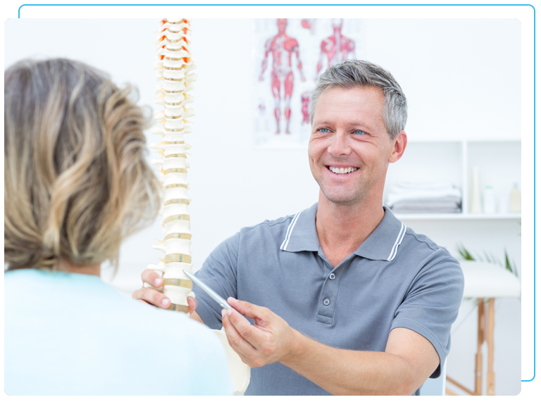 Chiropractor showing a patient a model of a spine
